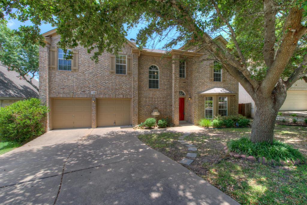 A classic brick exterior stands framed by mature 