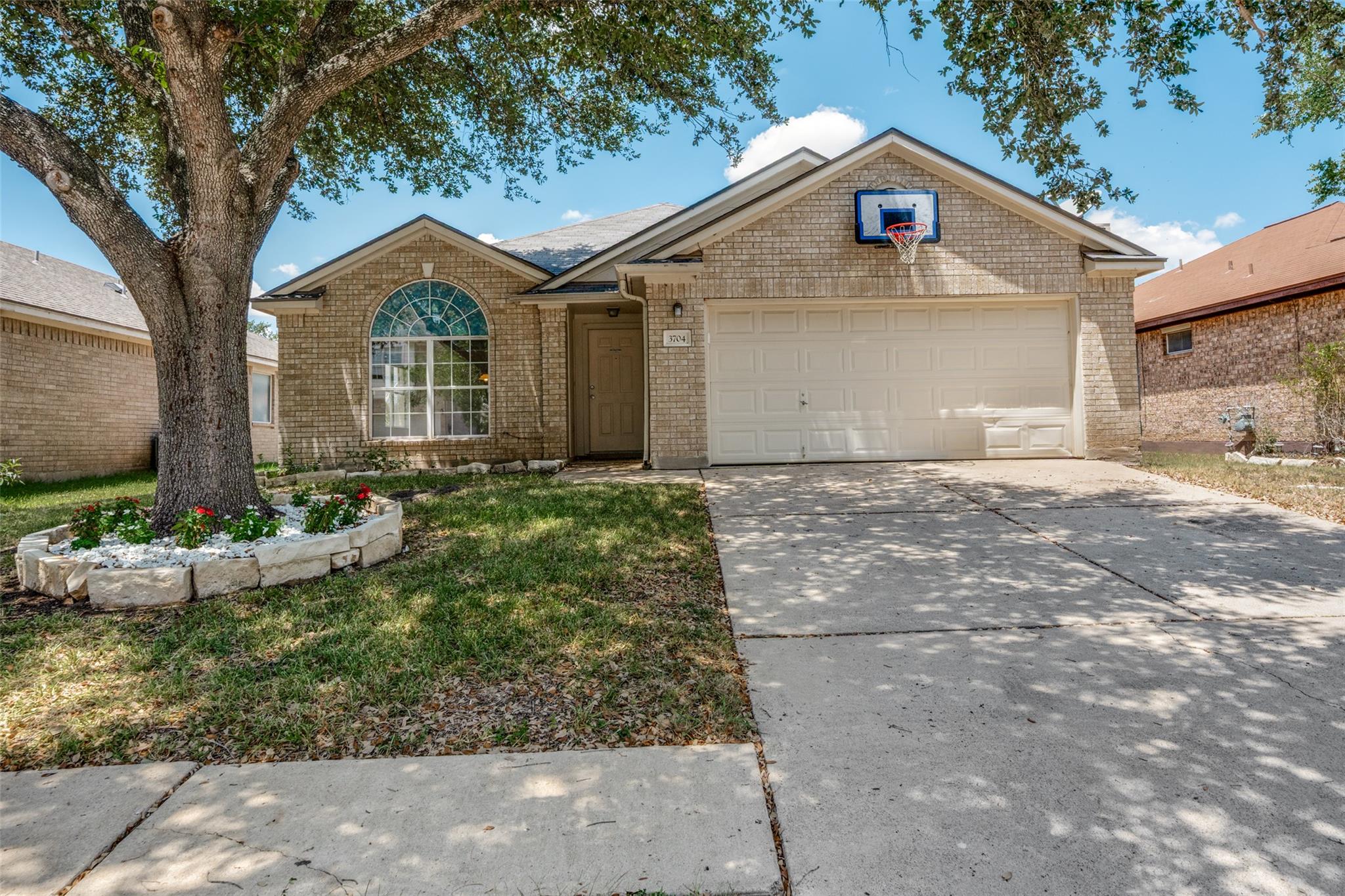Mature trees shade the classic brick exterior of 