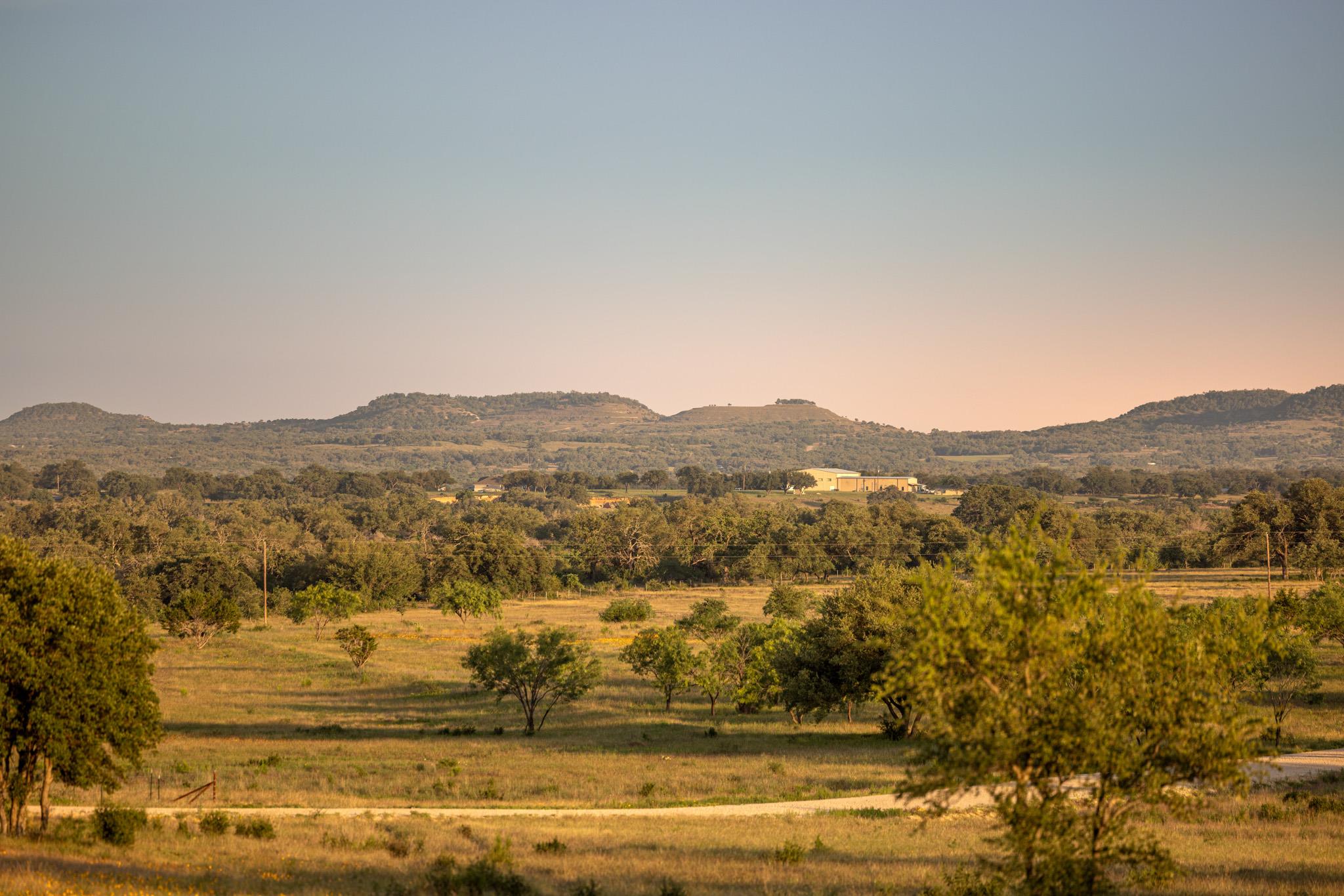 Rolling hills and mature trees frame the vast cou