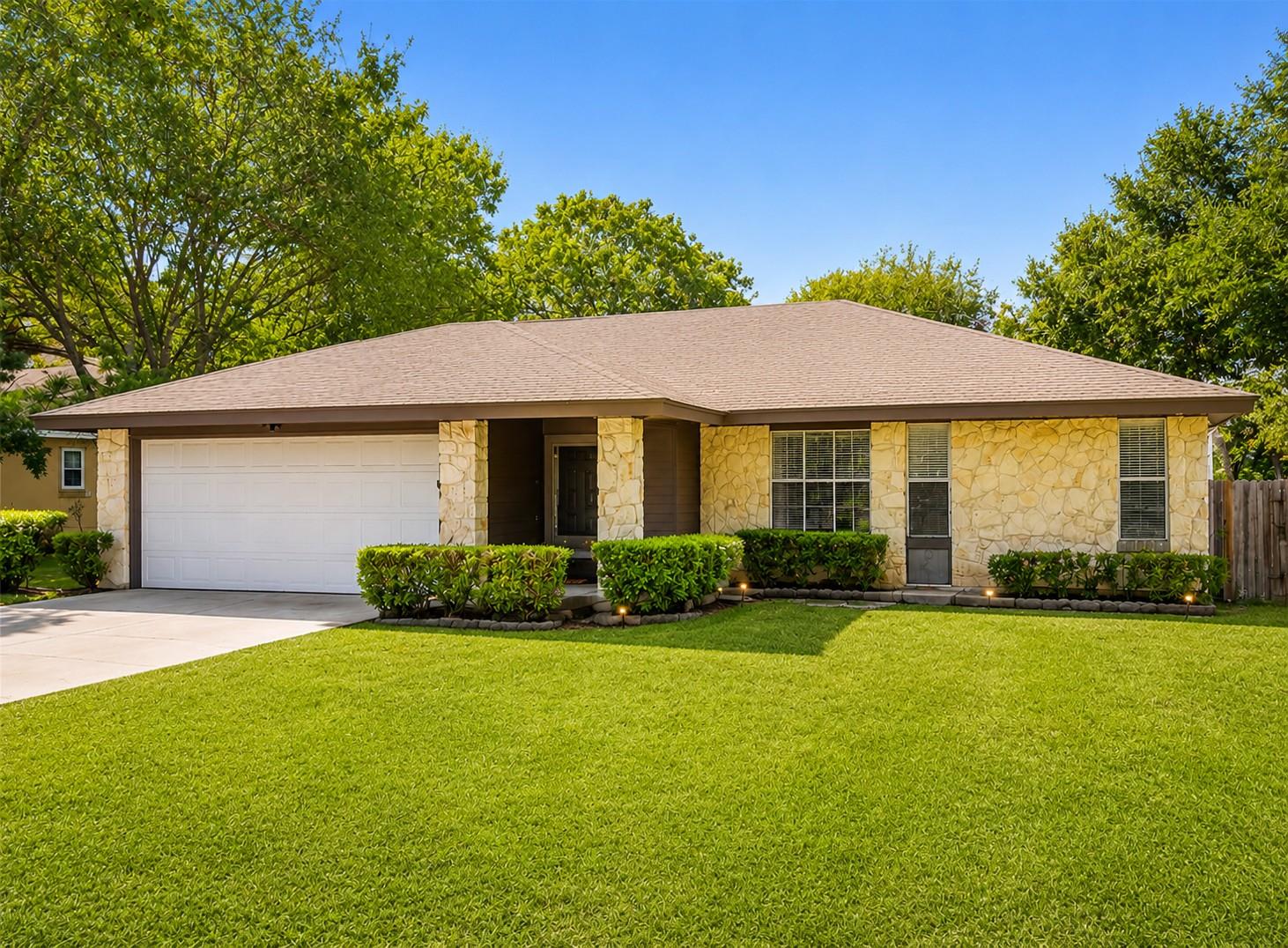 Textured stone accents and a manicured lawn frame
