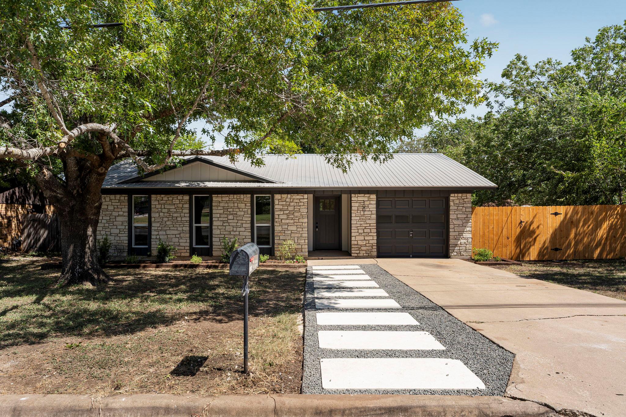 Mature trees shade a charming stone exterior acce