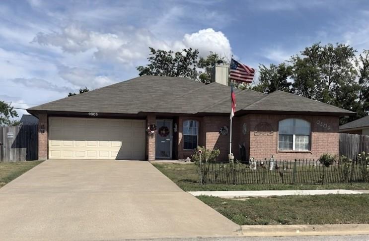 A classic brick exterior and long driveway establ