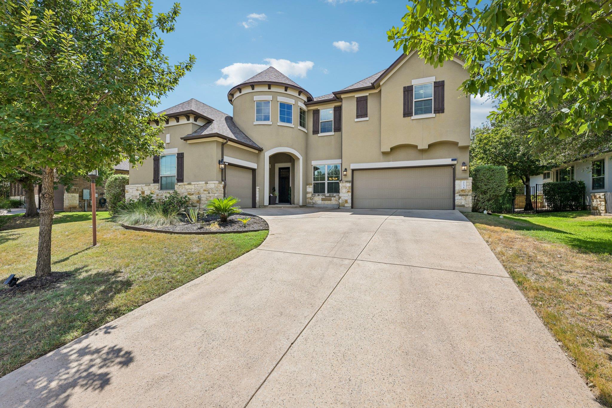 An elegant stucco and stone exterior anchors the 