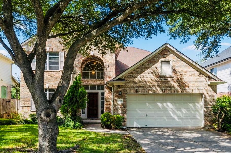 Mature shade trees frame a classic brick exterior