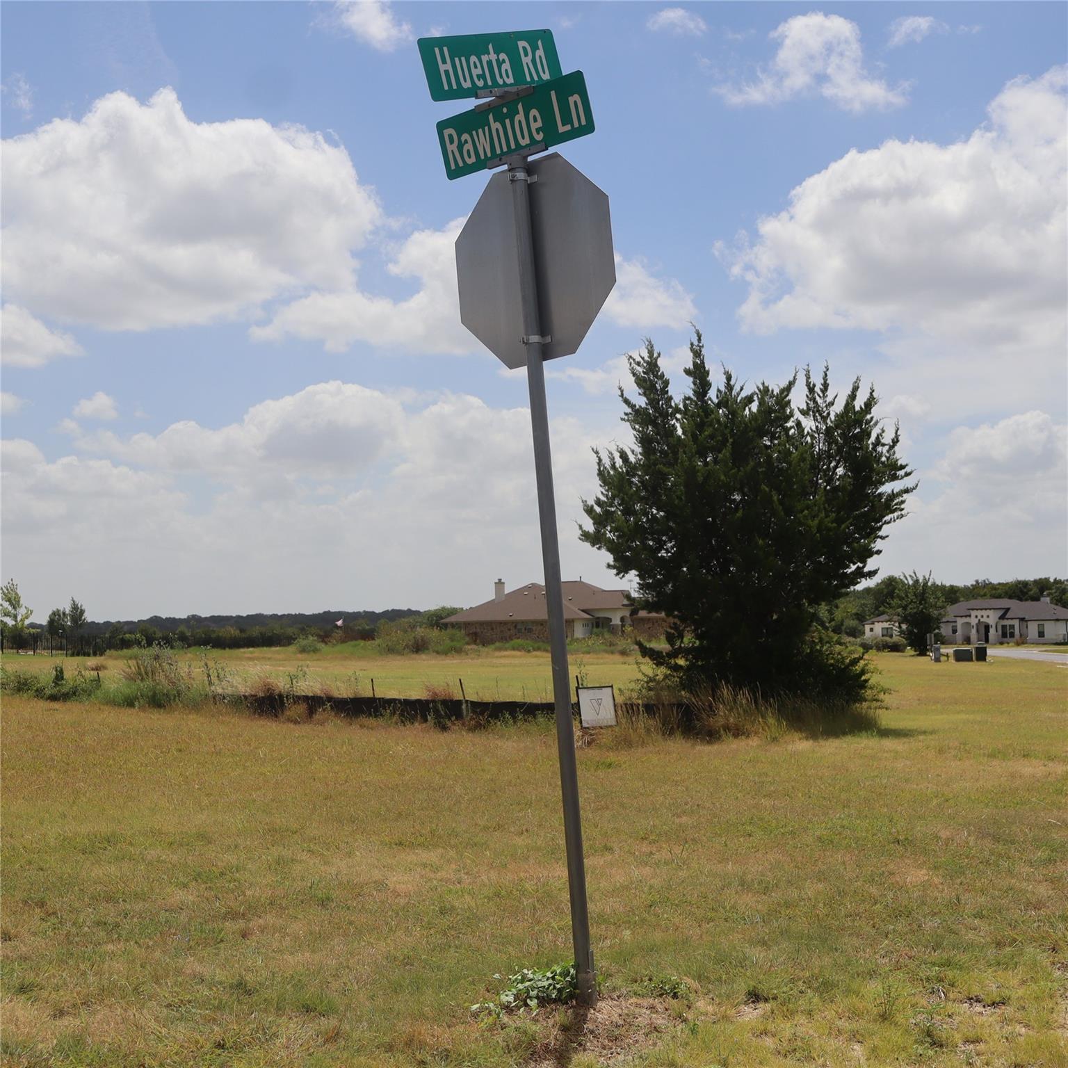 A spacious vacant lot sits under a blue sky at a 