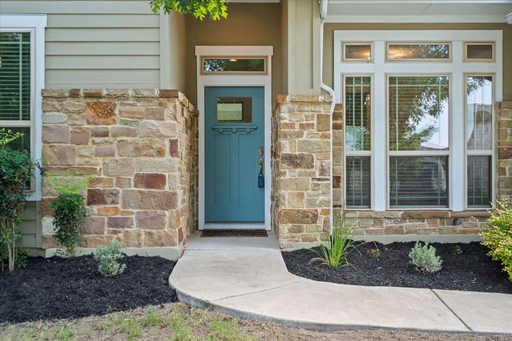 Stone accents and a curved concrete walkway frame