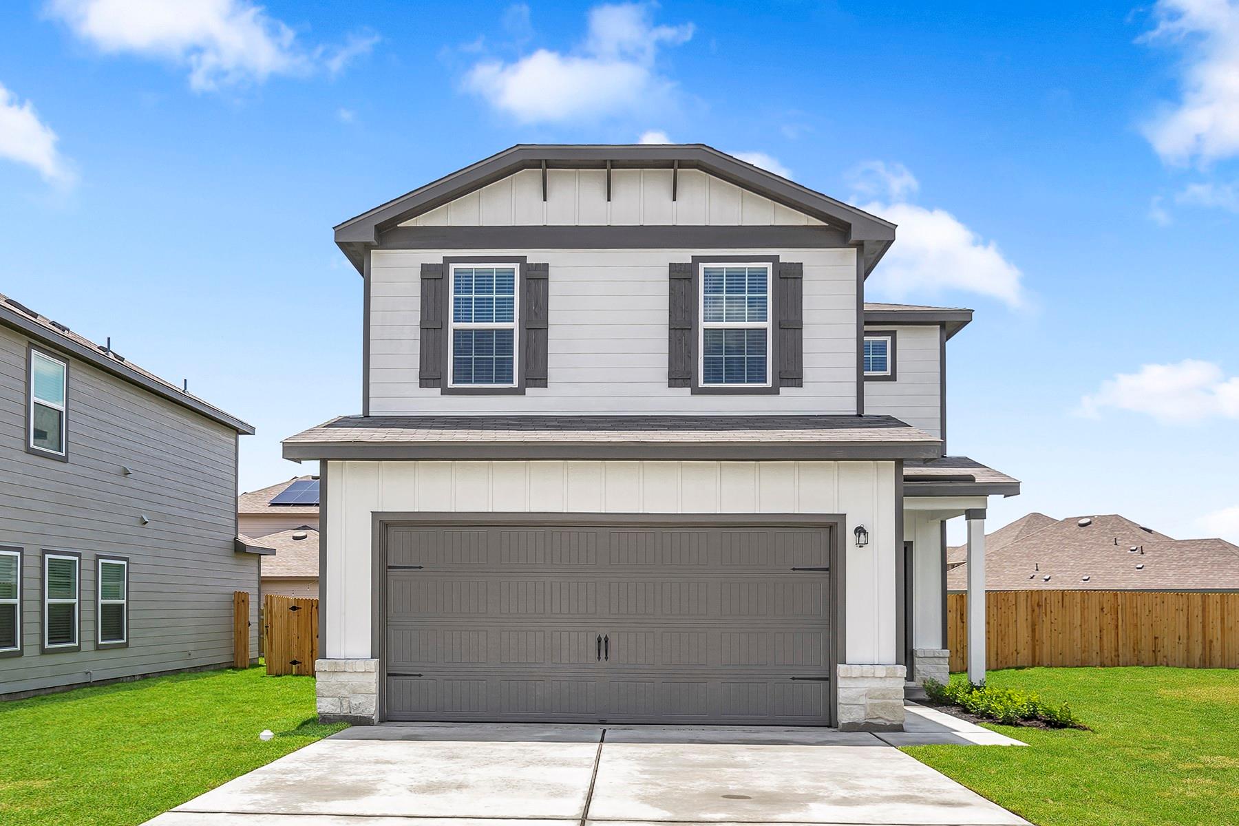An inviting exterior features a concrete driveway