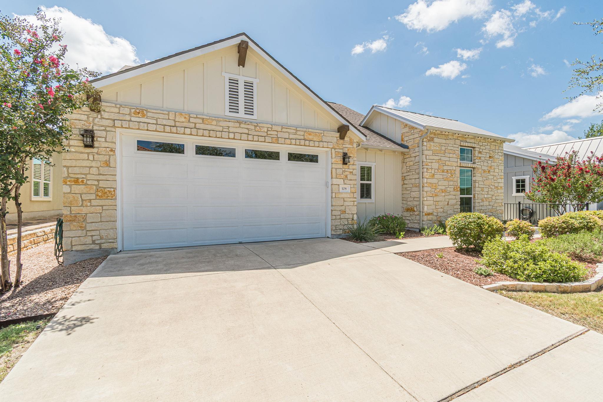 Natural stone masonry and vertical siding create 