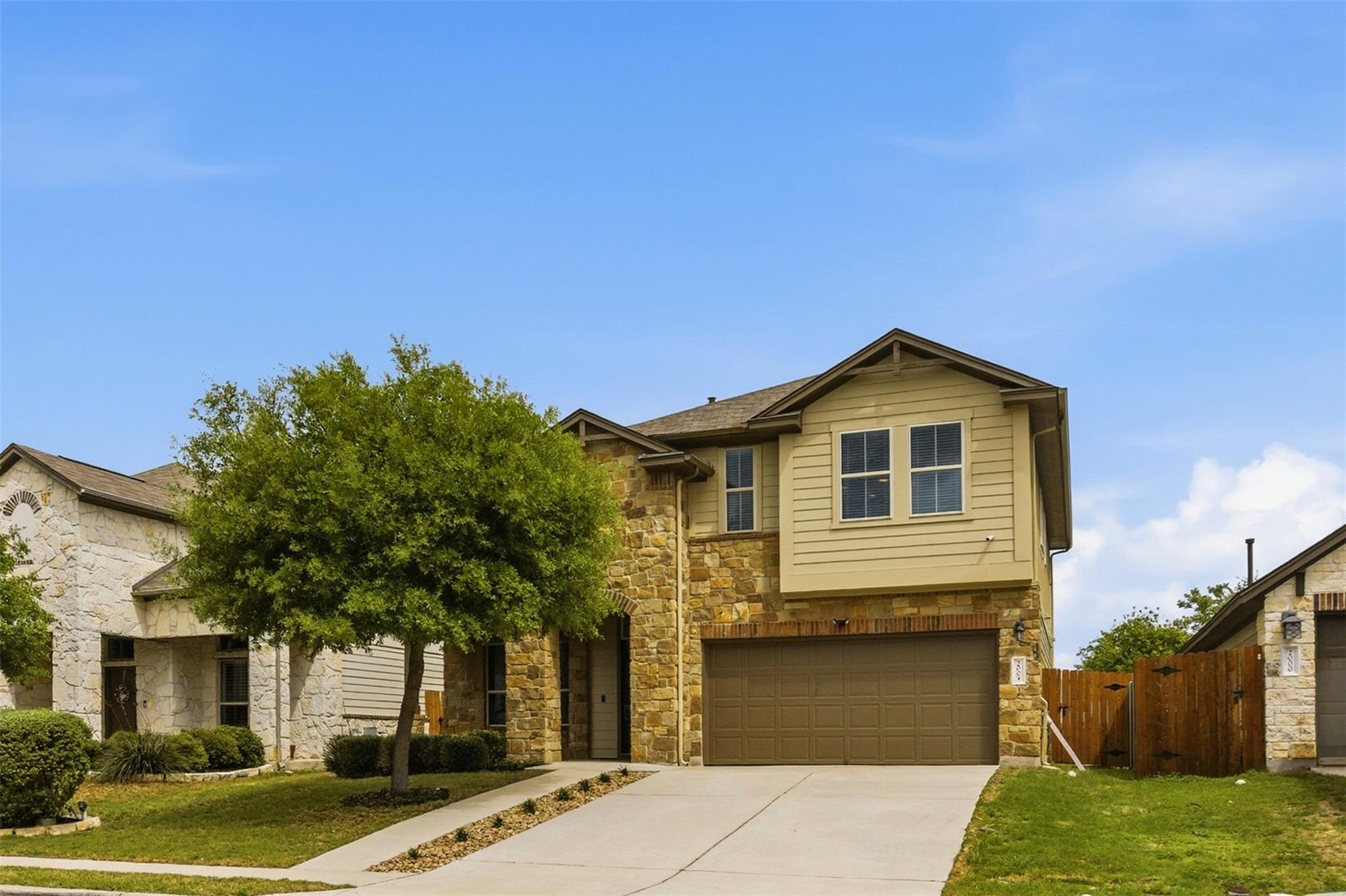 Natural stone accents and a concrete driveway def