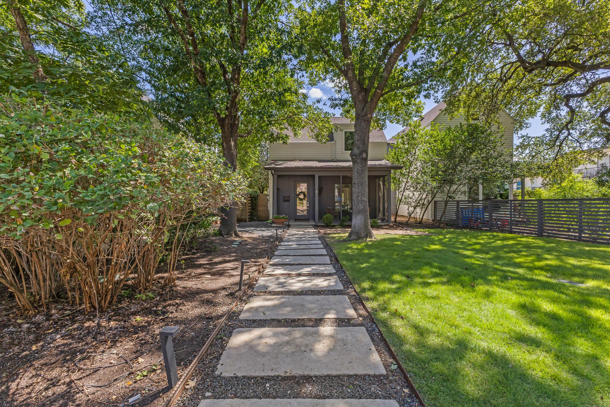 Mature trees shade a stepping stone path leading 