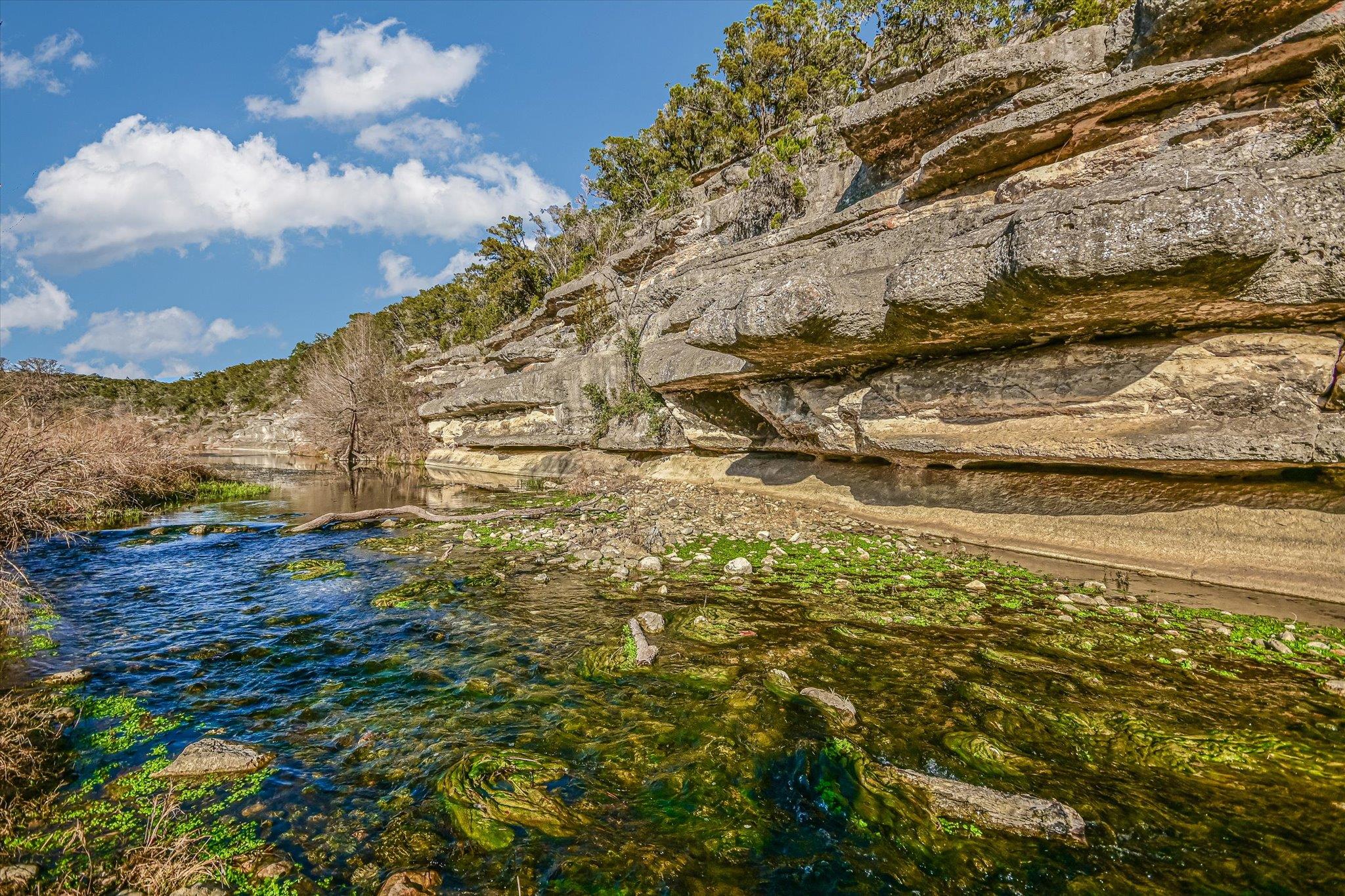 Dramatic limestone bluffs tower over the clear, w