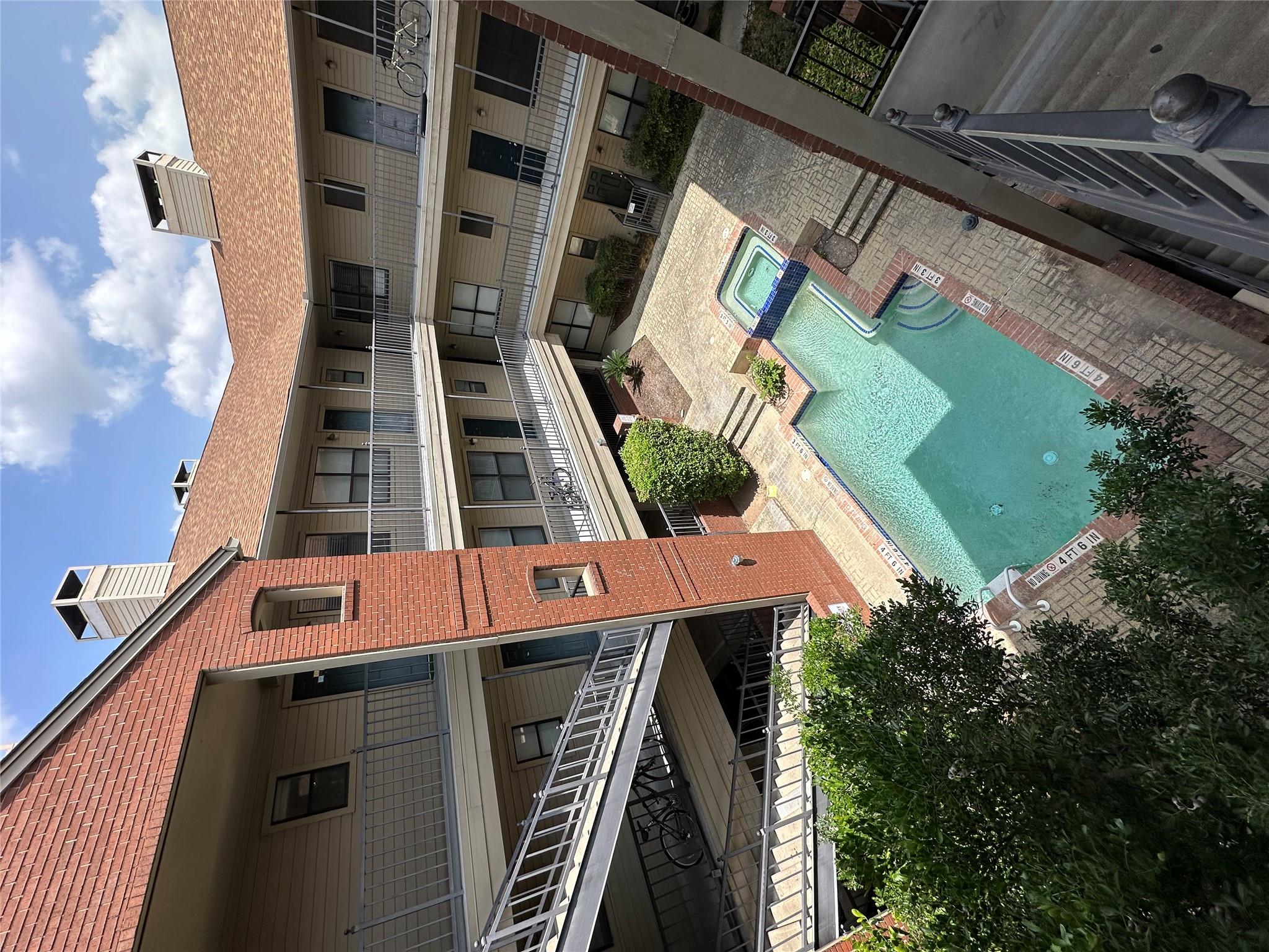 A central courtyard features a sparkling pool and