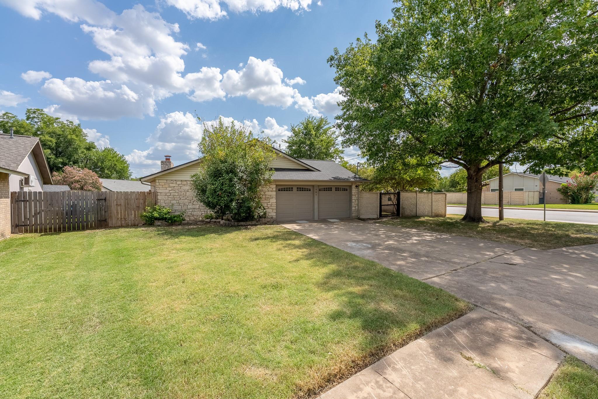Mature trees shade a spacious front lawn leading 