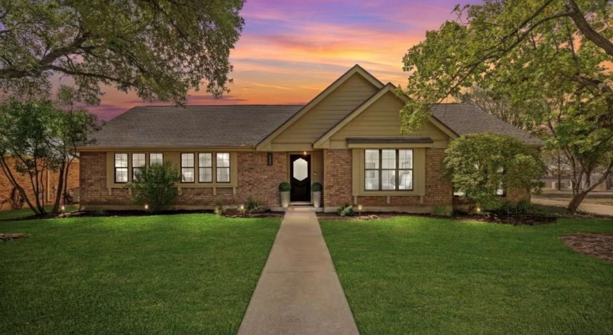 Mature trees frame a classic brick exterior set b