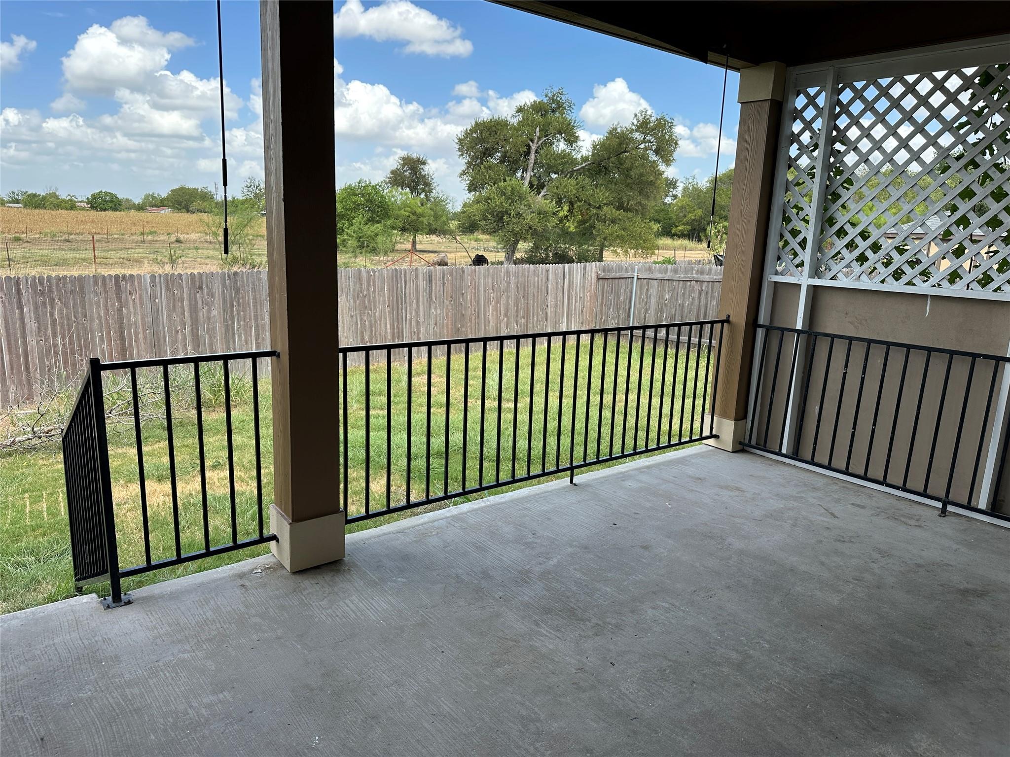 Concrete patio flooring meets a metal railing ove
