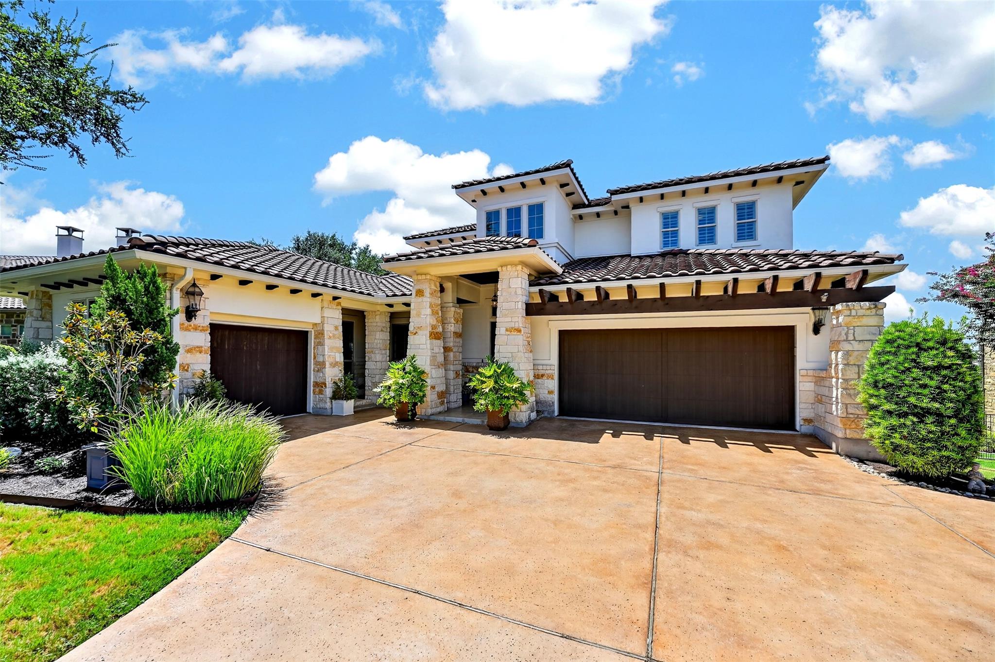Natural stone accents and tiled rooflines define 