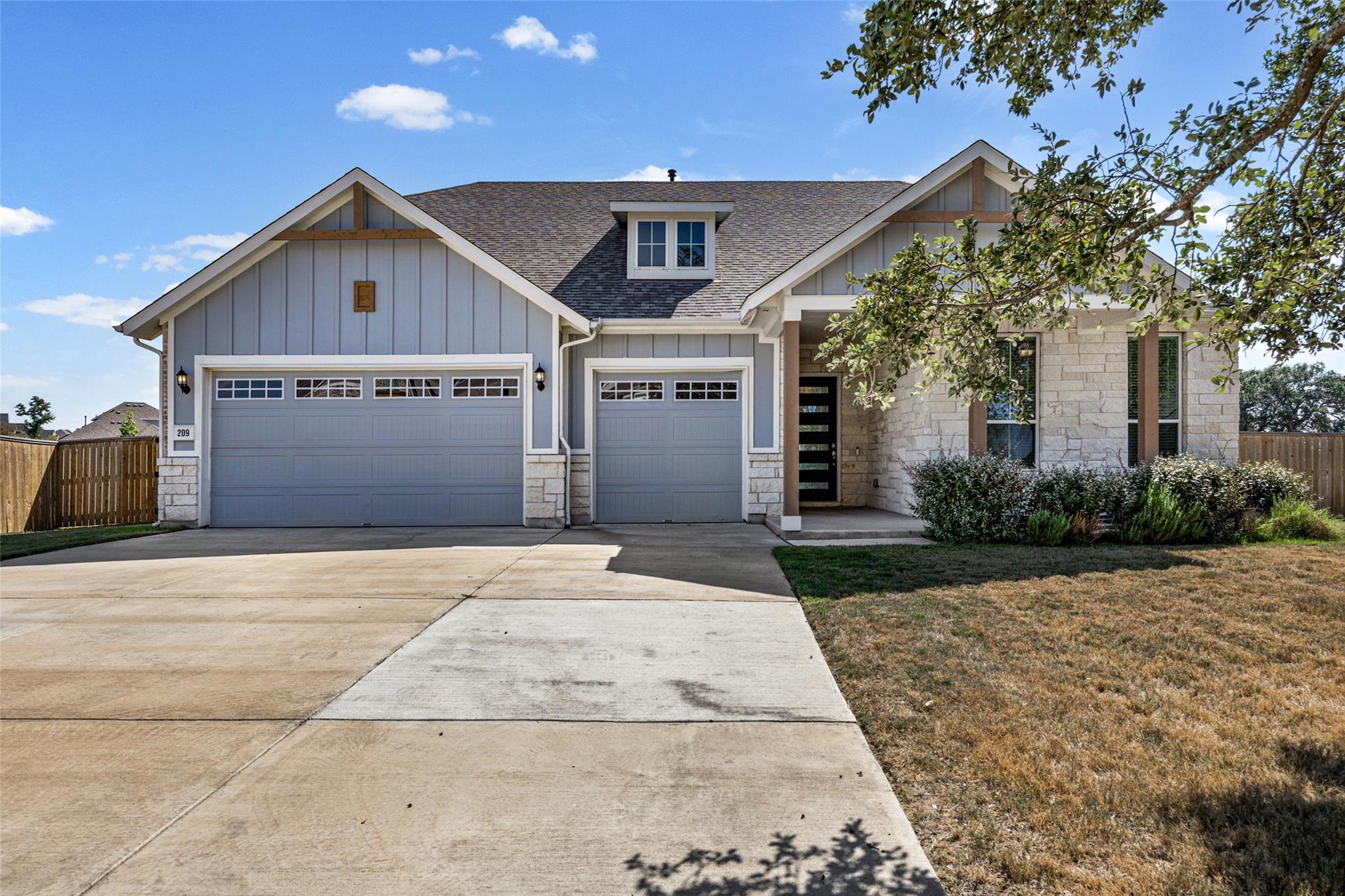A spacious concrete driveway leads to this modern
