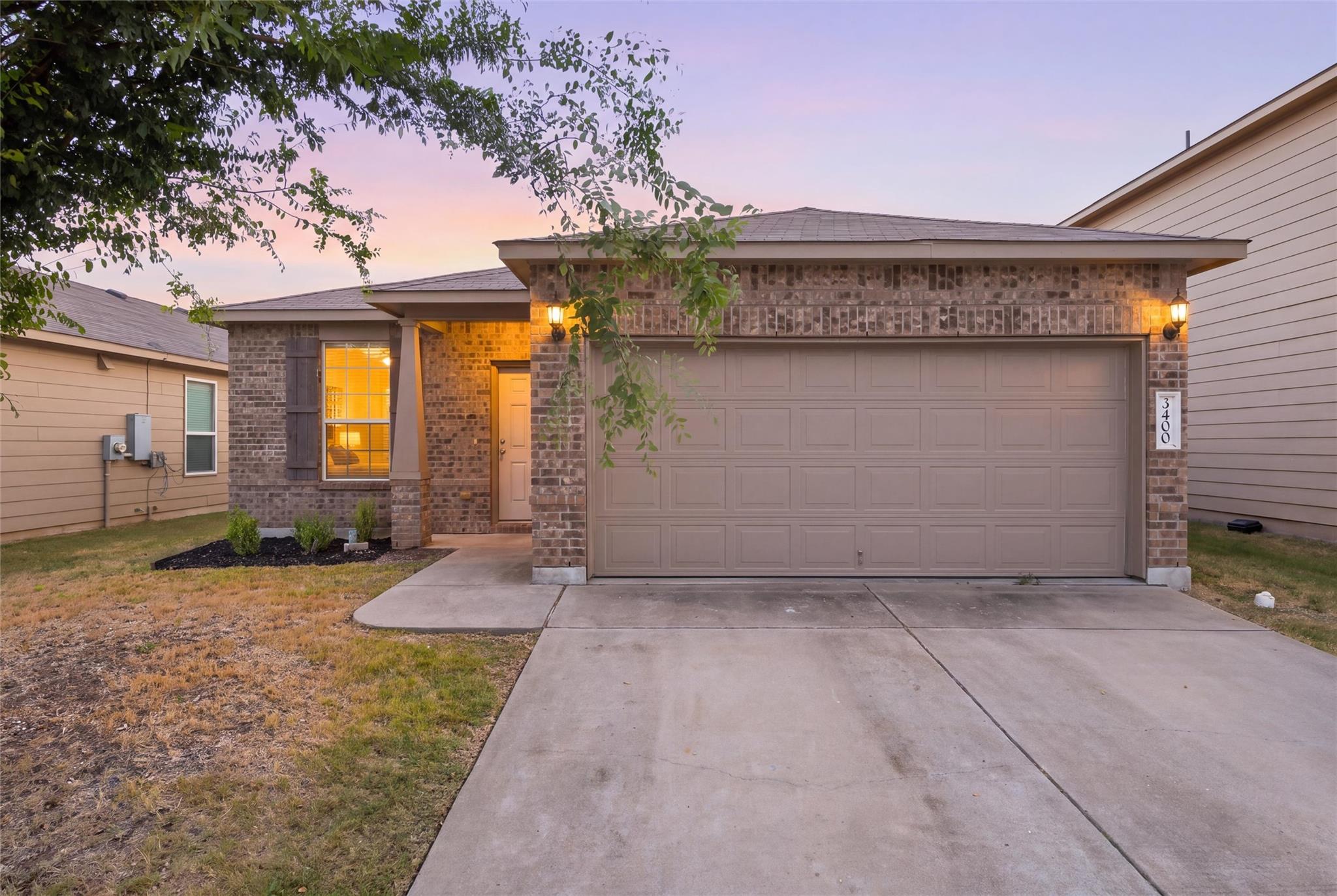 Brick accents and a spacious concrete driveway de