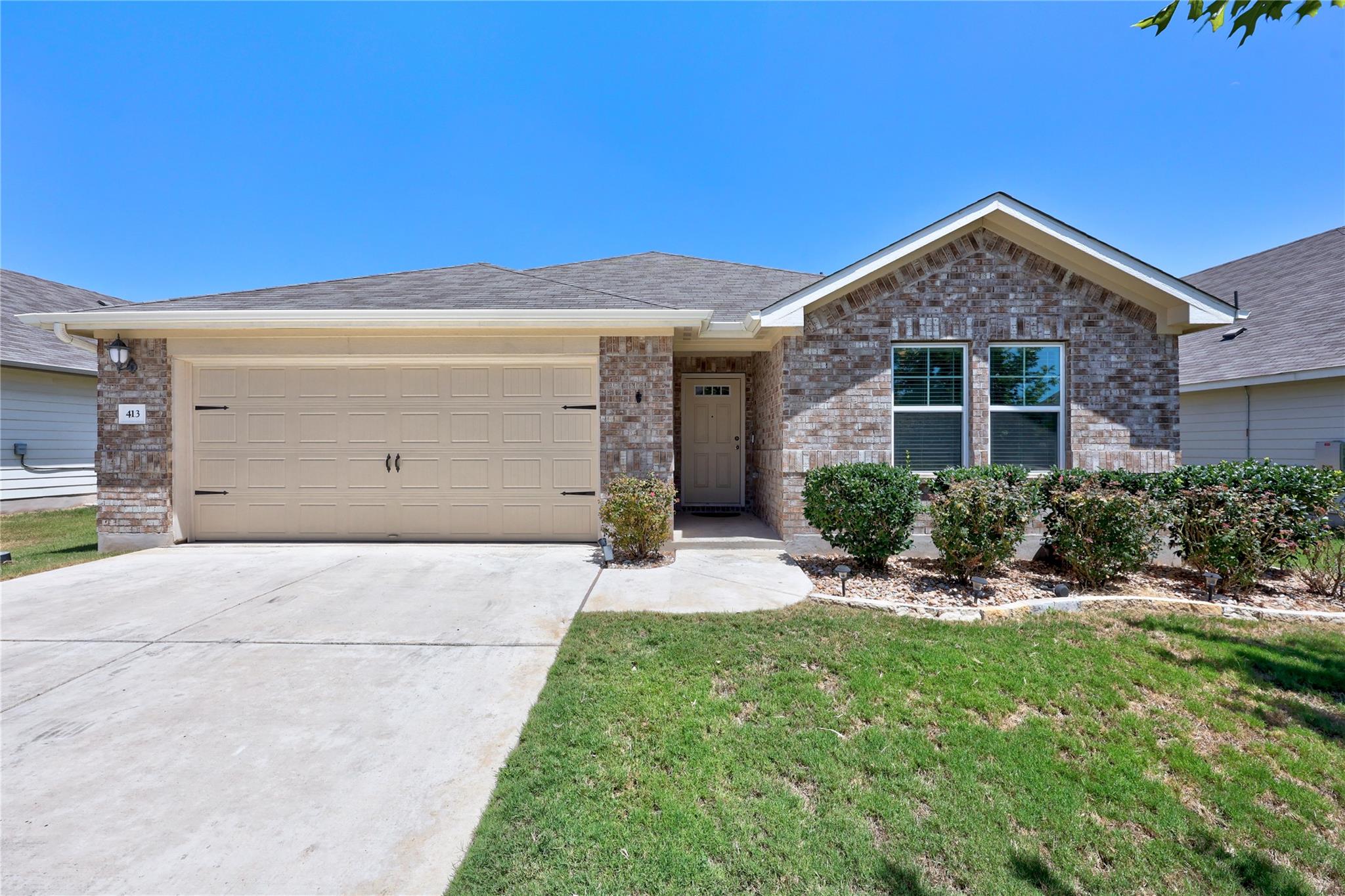 Classic brick exterior and a neat concrete drivew