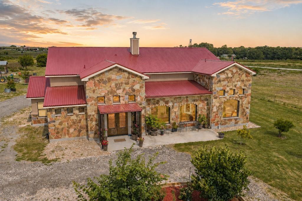 Textured stone siding and a bold metal roof defin