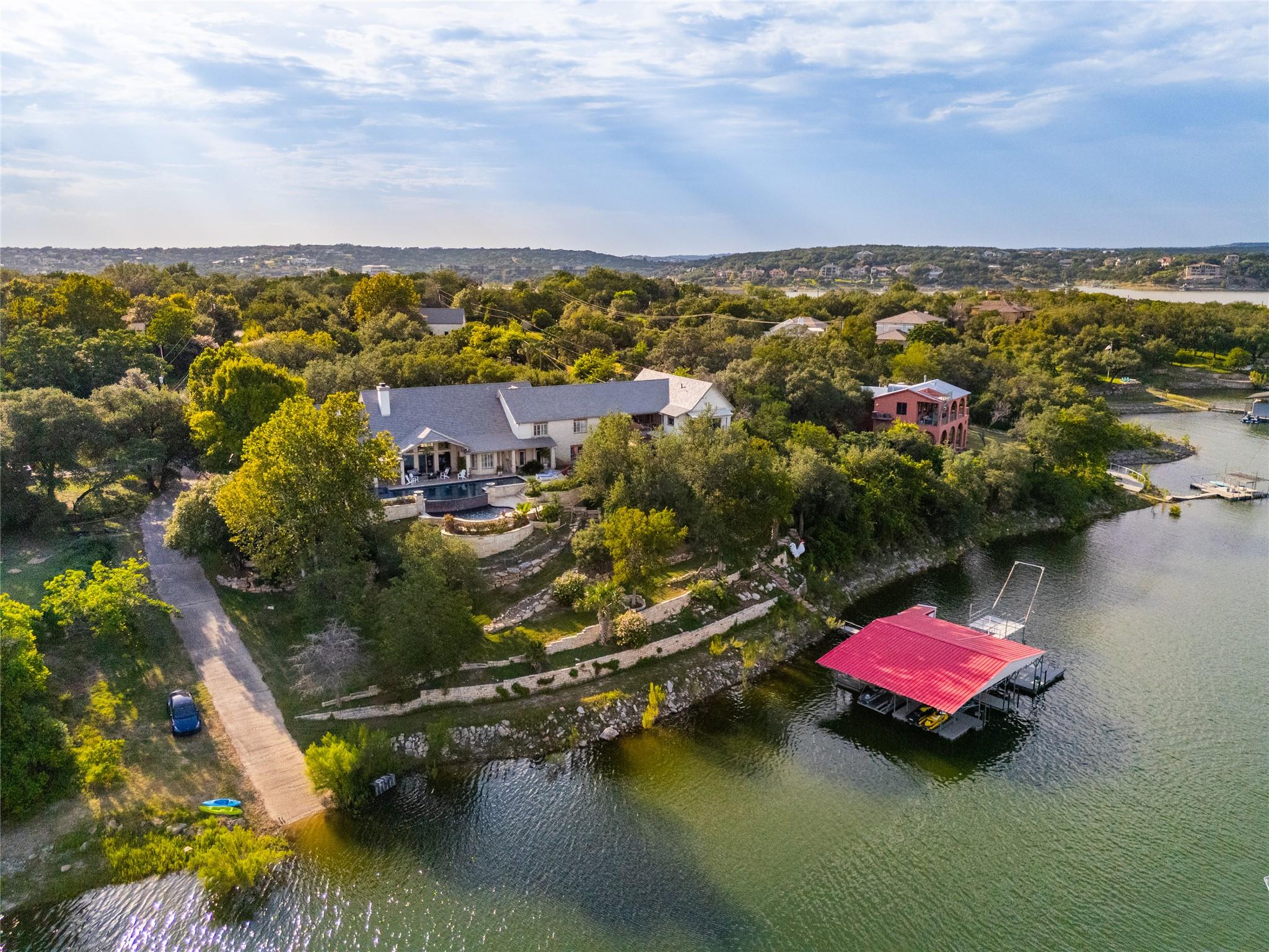 Lush trees surround a lakeside estate featuring a