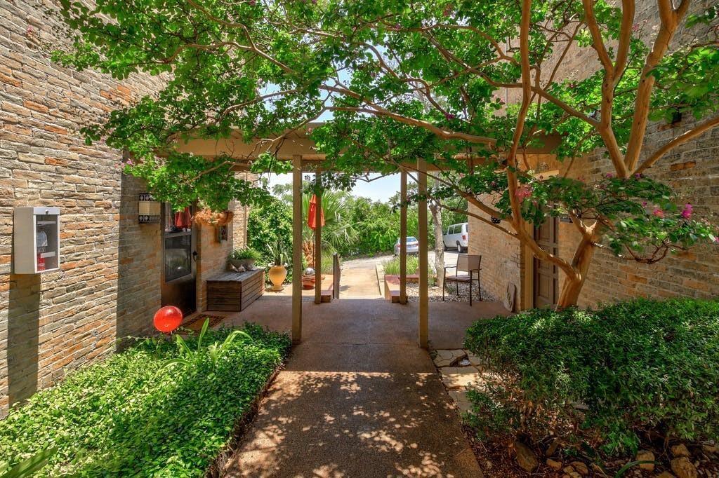 Mature trees shade a welcoming stone entry pathwa