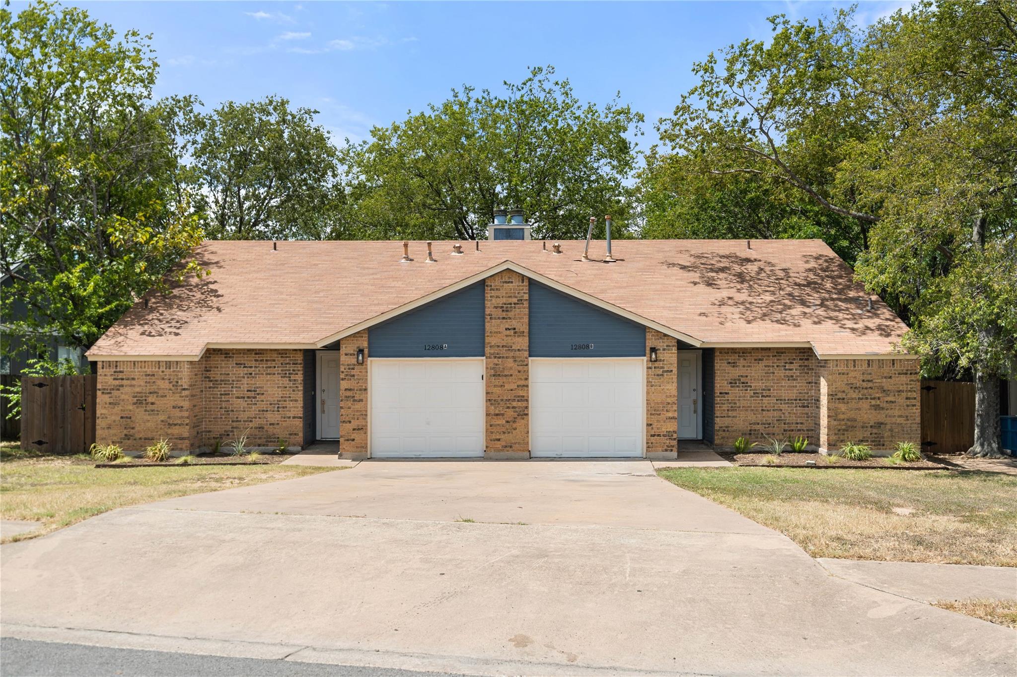 Classic brick accents and a spacious concrete dri