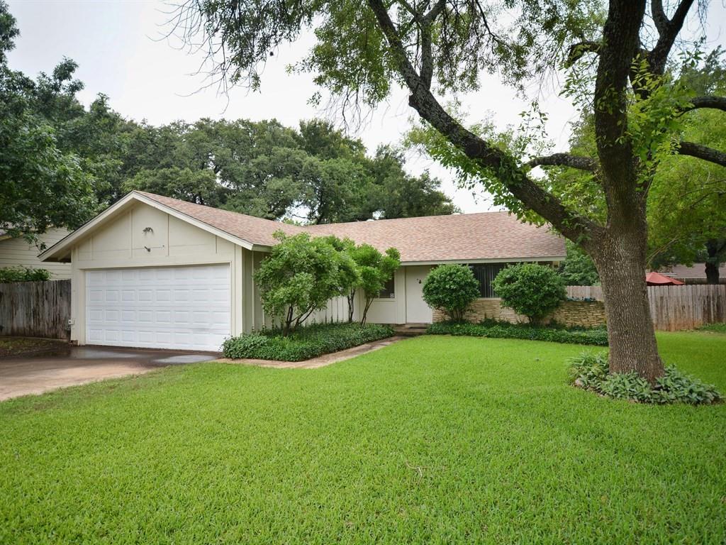 Mature trees shade a spacious green lawn leading 
