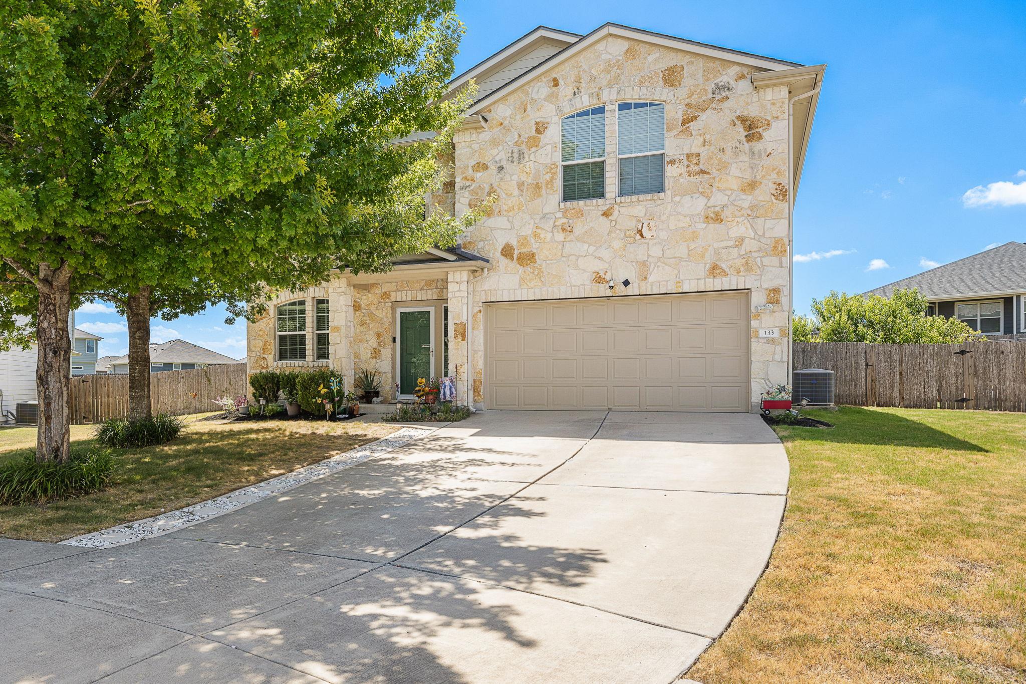 Natural stone masonry and a wide concrete drivewa