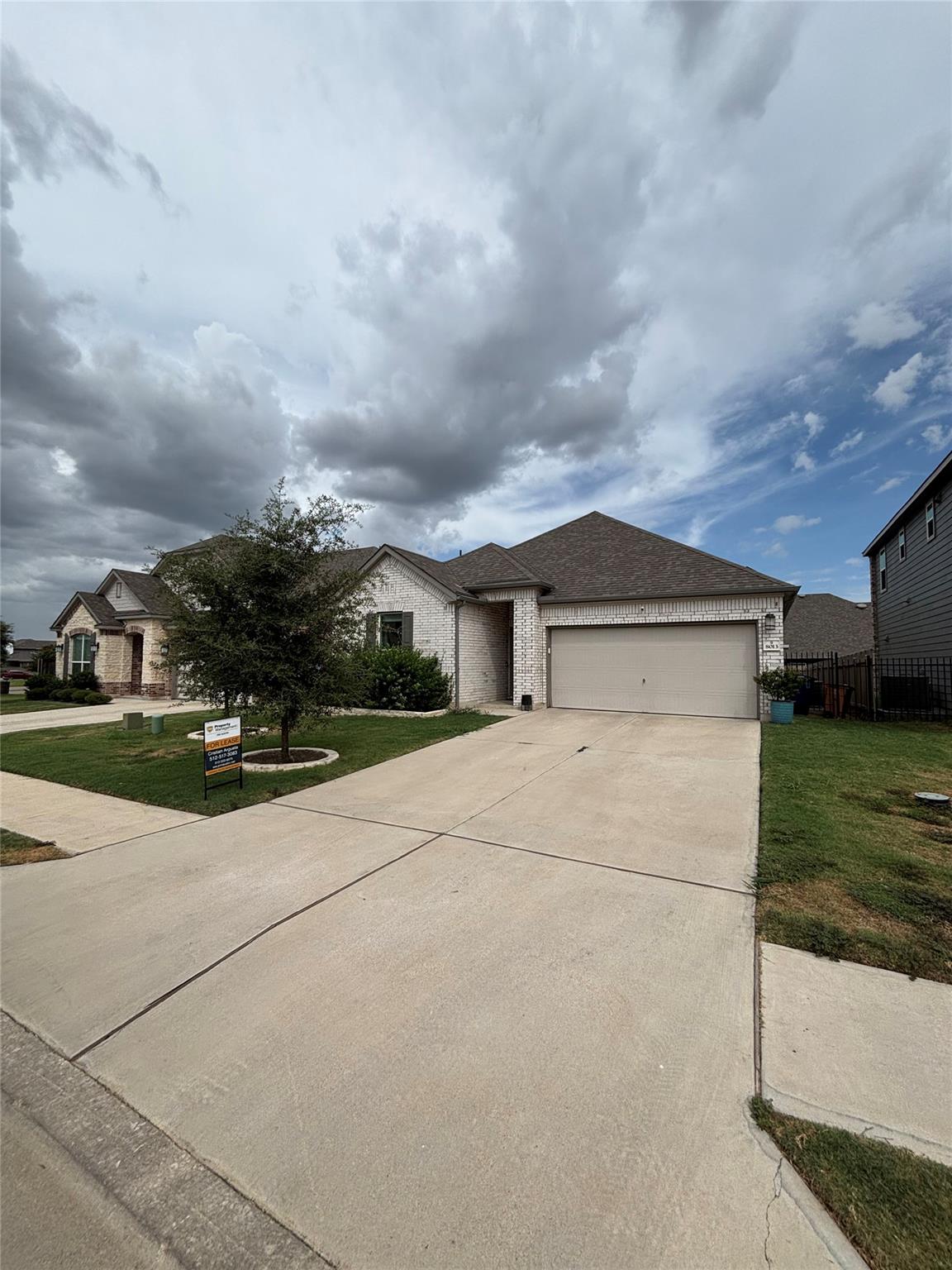 A spacious concrete driveway leads to the attache