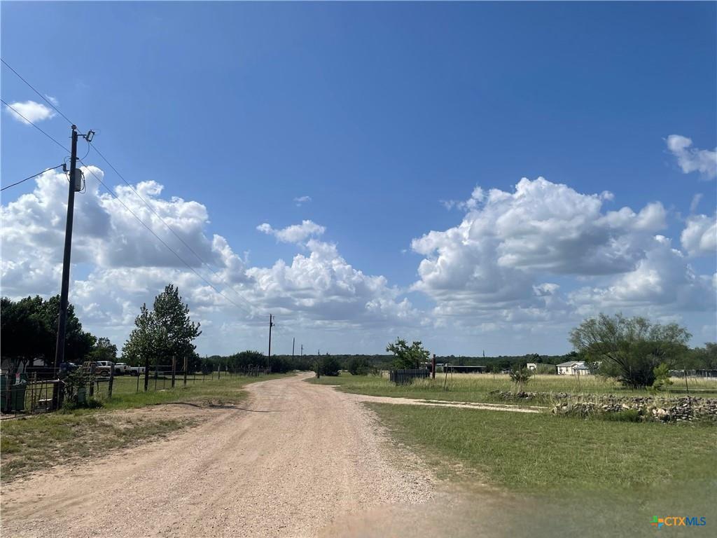 An unpaved country lane winds through open fields