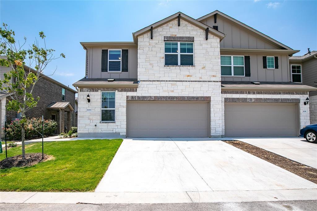 White stone accents and a spacious concrete drive