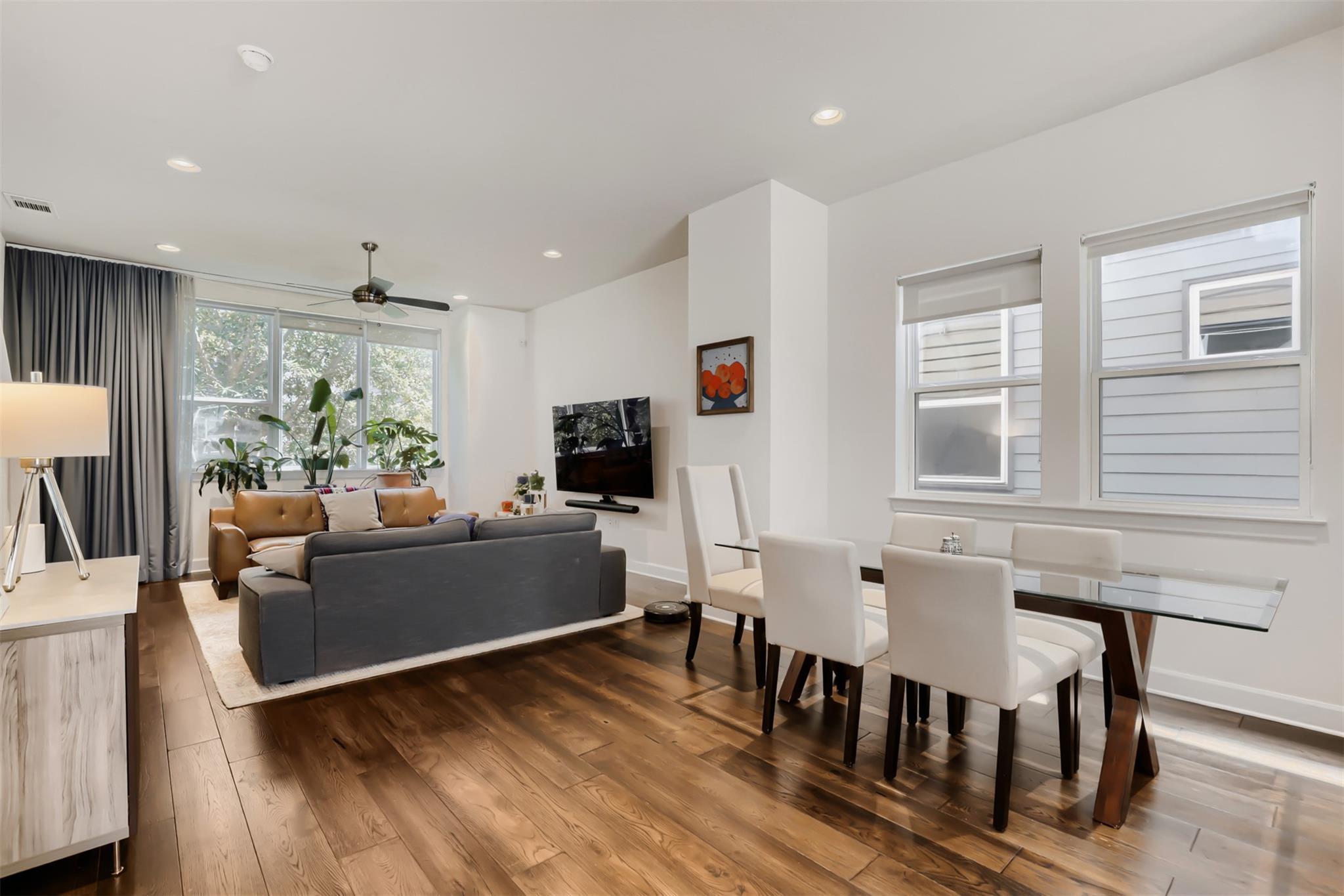 Rich hardwood flooring complements the bright, op