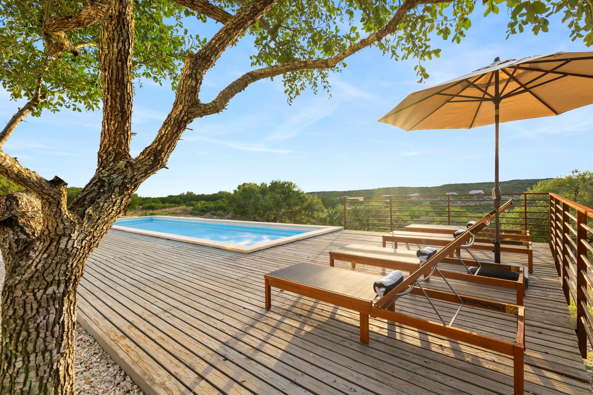An elevated wooden deck surrounds the sparkling p