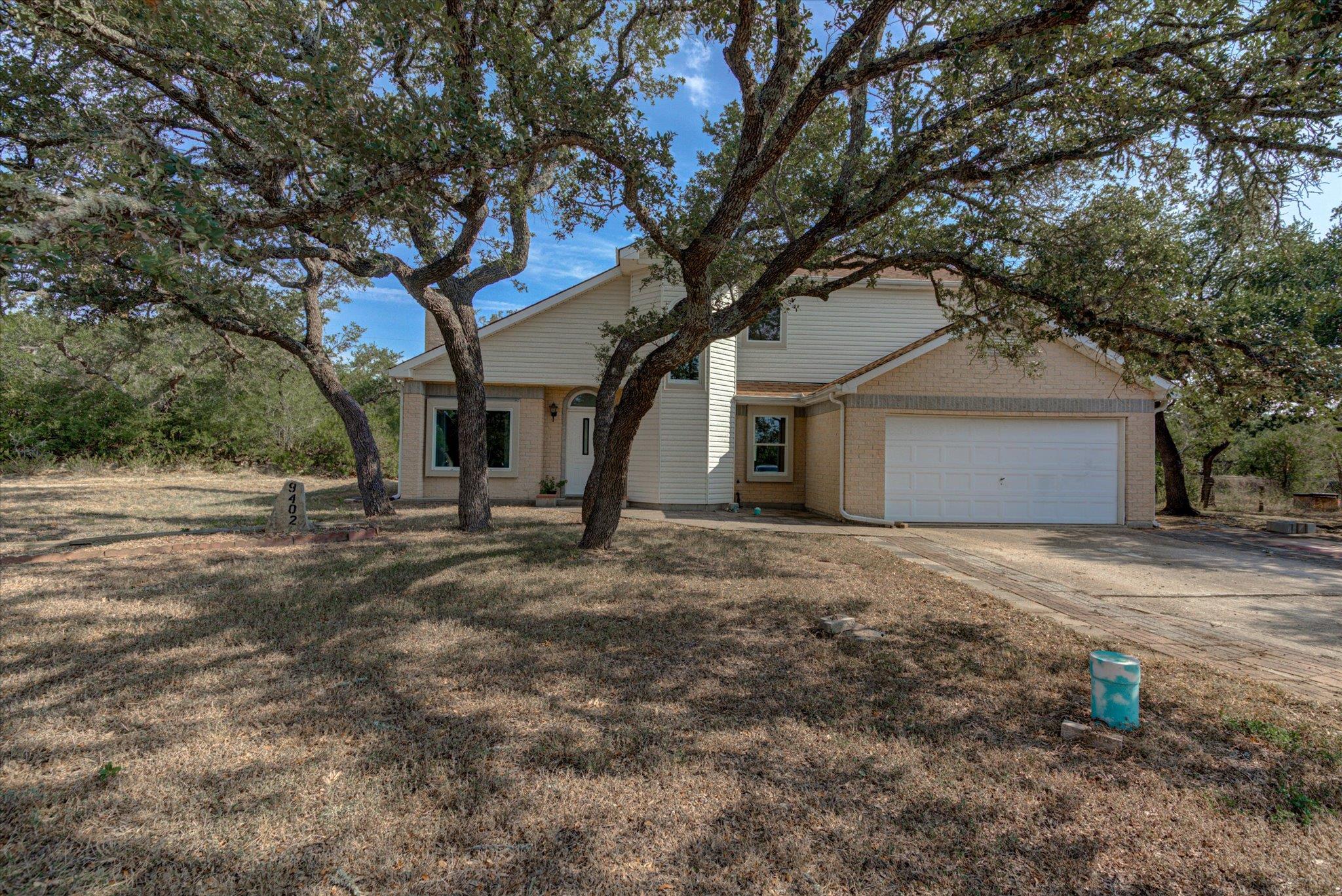 Mature oak trees shade the front yard of this bri