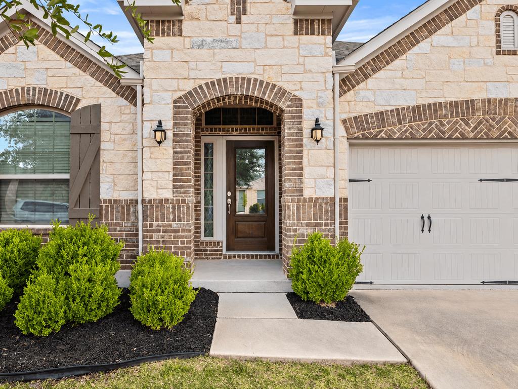 An arched entry and stone accents define the invi