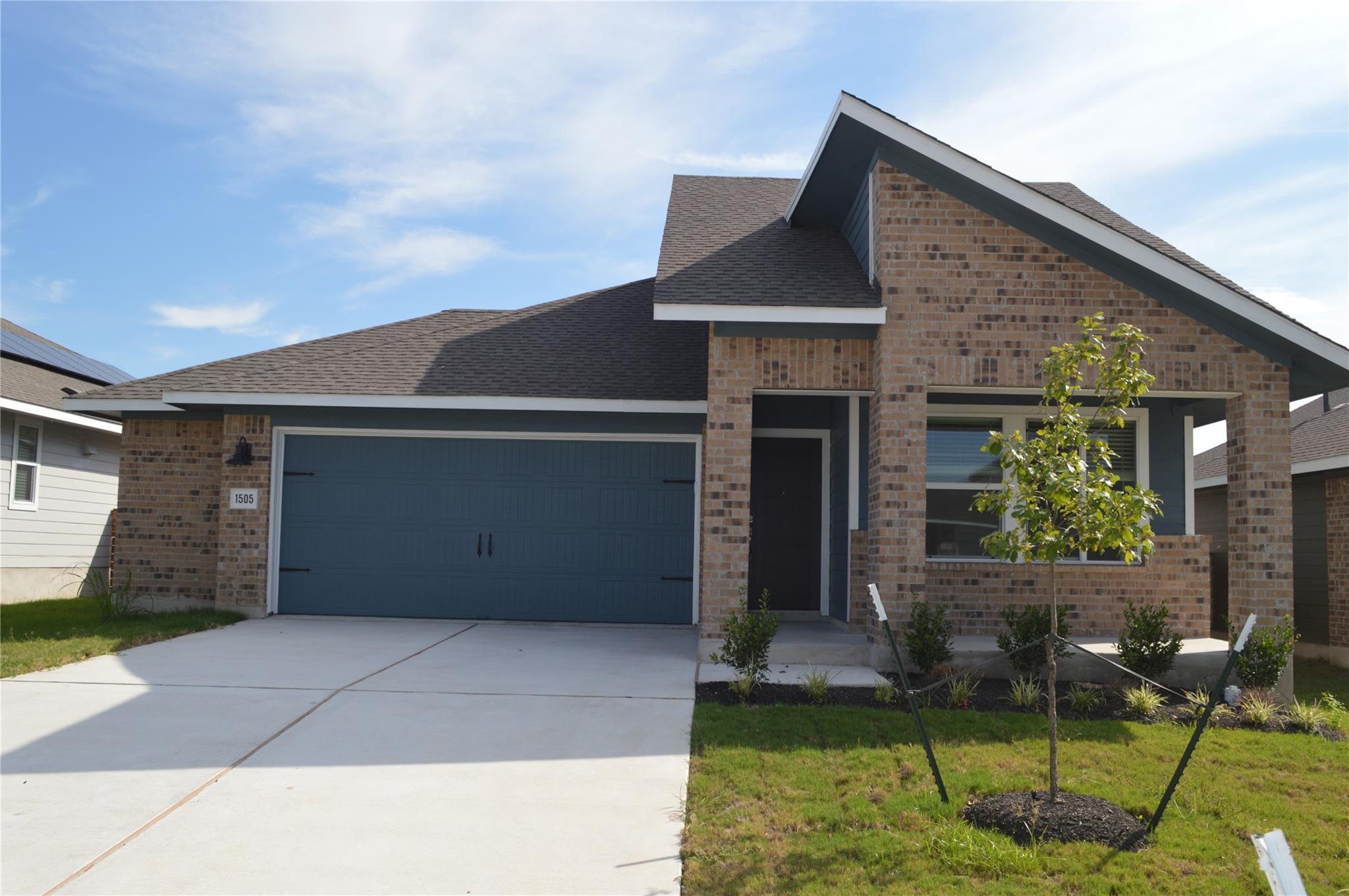 Multi-textured brickwork and a concrete driveway 