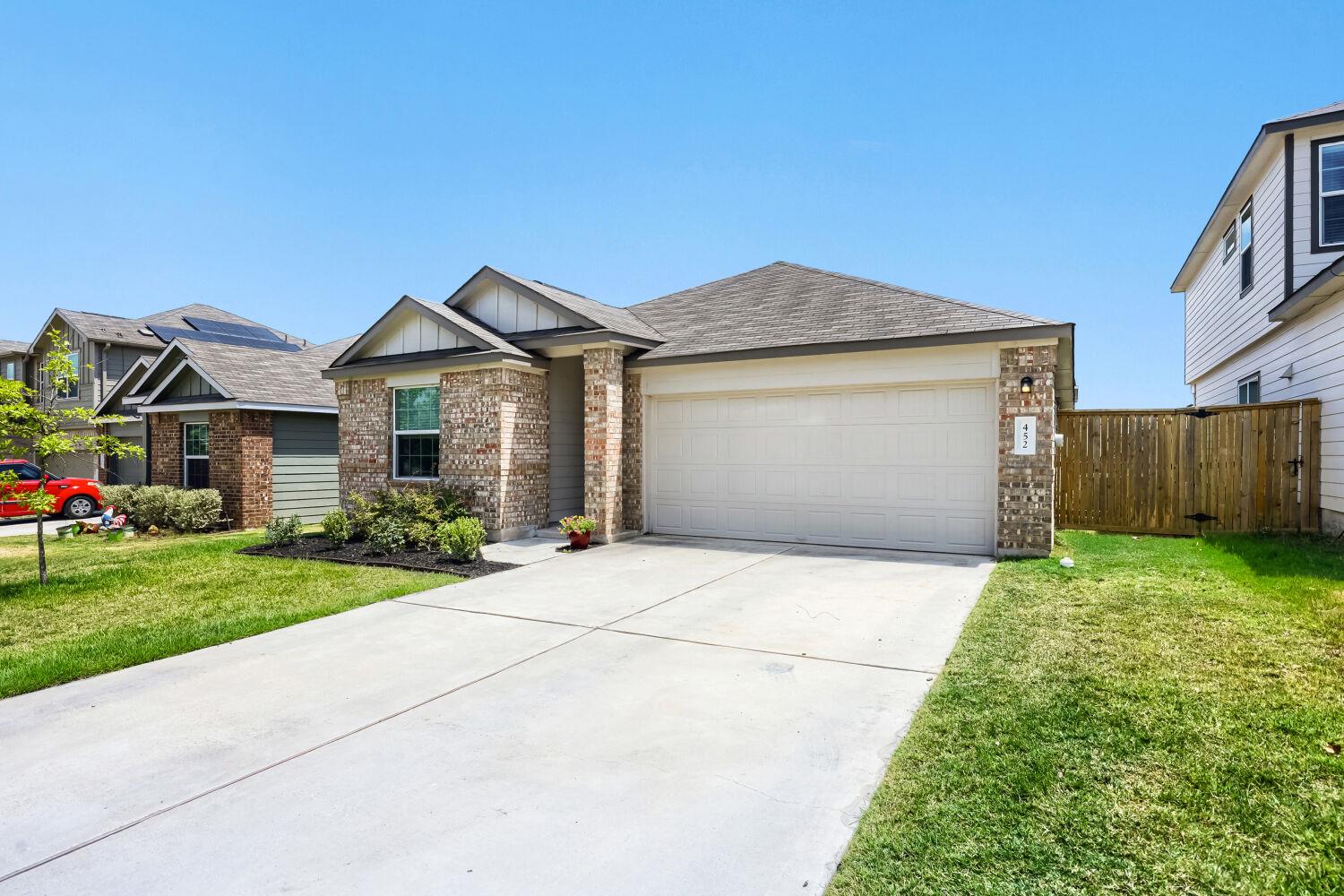 Classic brick accents and a neat concrete drivewa