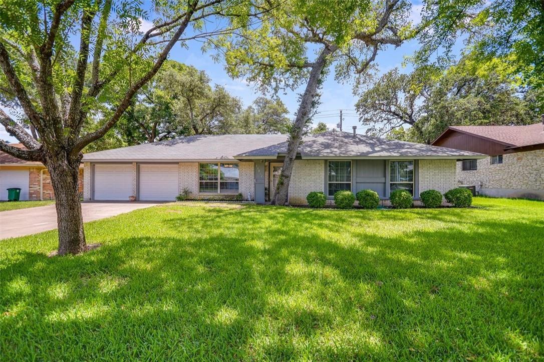 Mature shade trees frame a classic single-story b