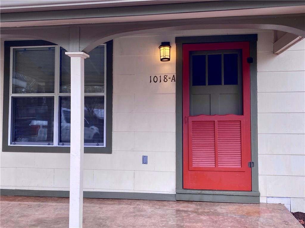 A welcoming front porch features a charming scree