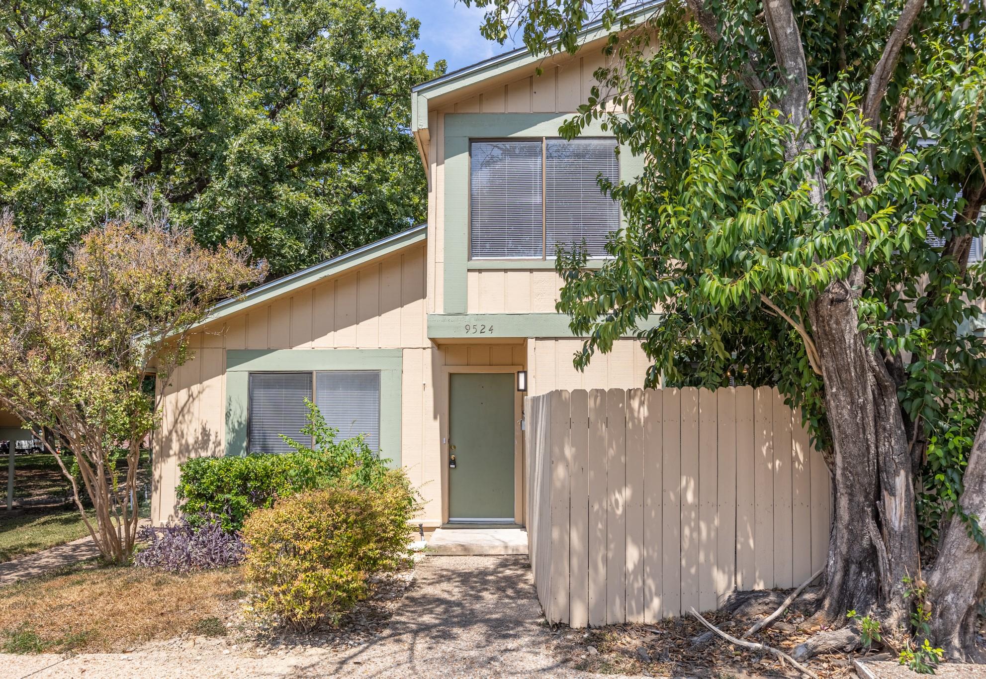 Mature trees frame a welcoming entryway featuring