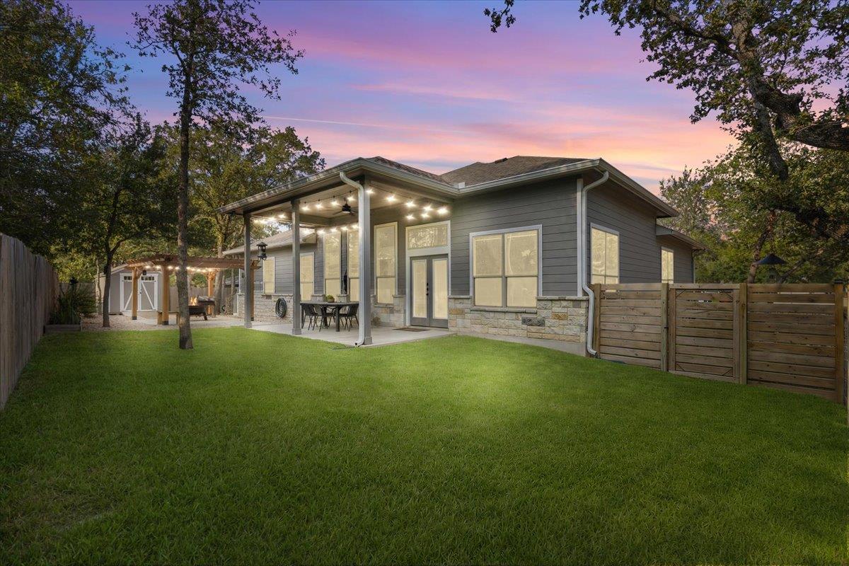 A spacious lawn transitions to a covered back pat