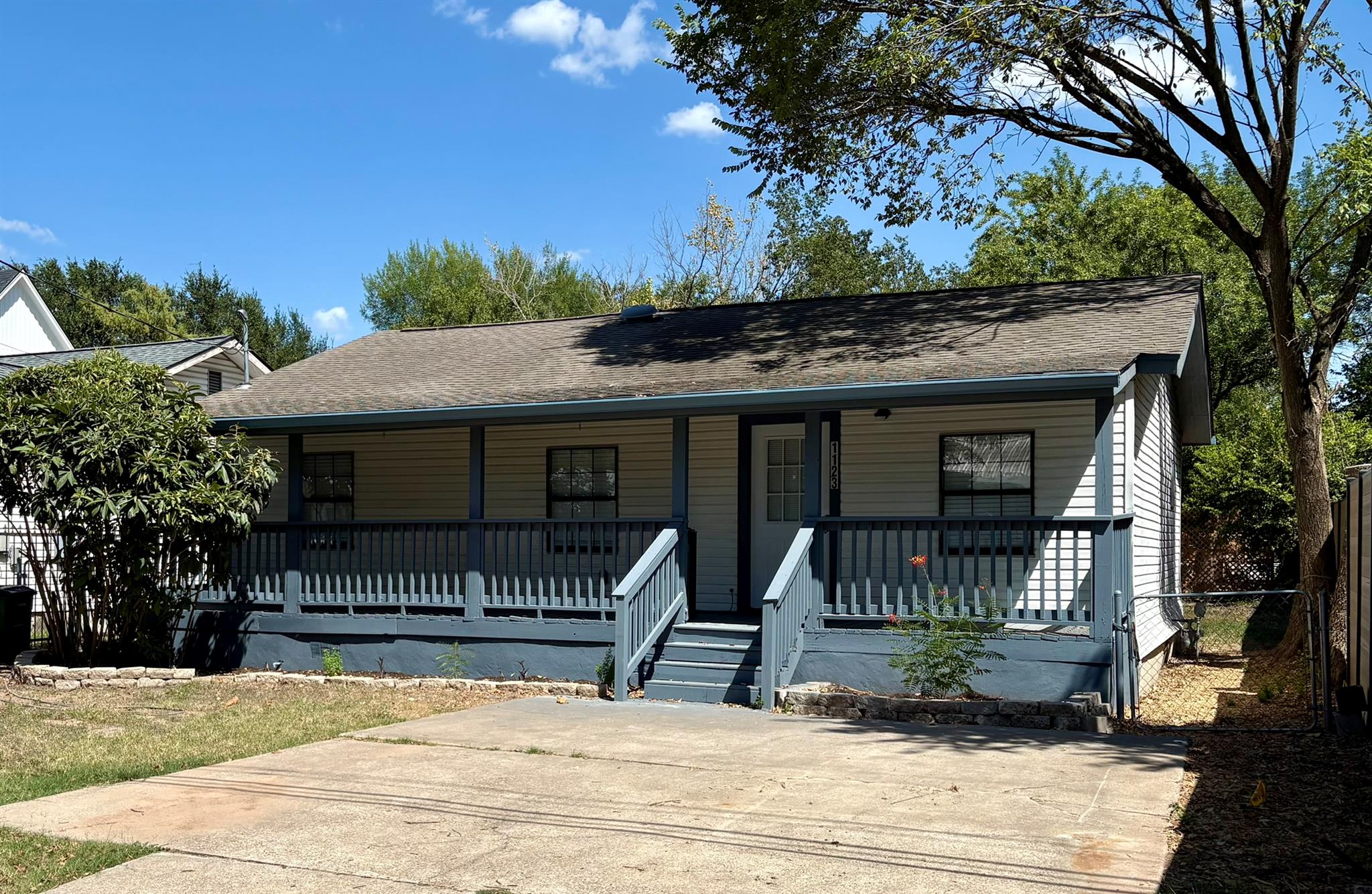 An inviting covered front porch runs the full len