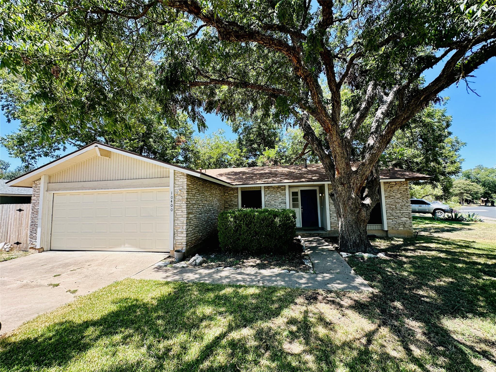 Mature shade trees frame a stone-accented exterio