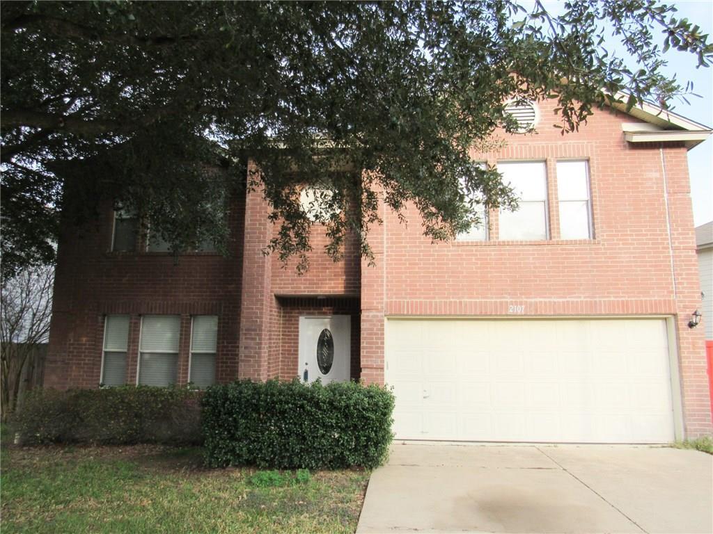 Mature trees frame a classic brick exterior with 