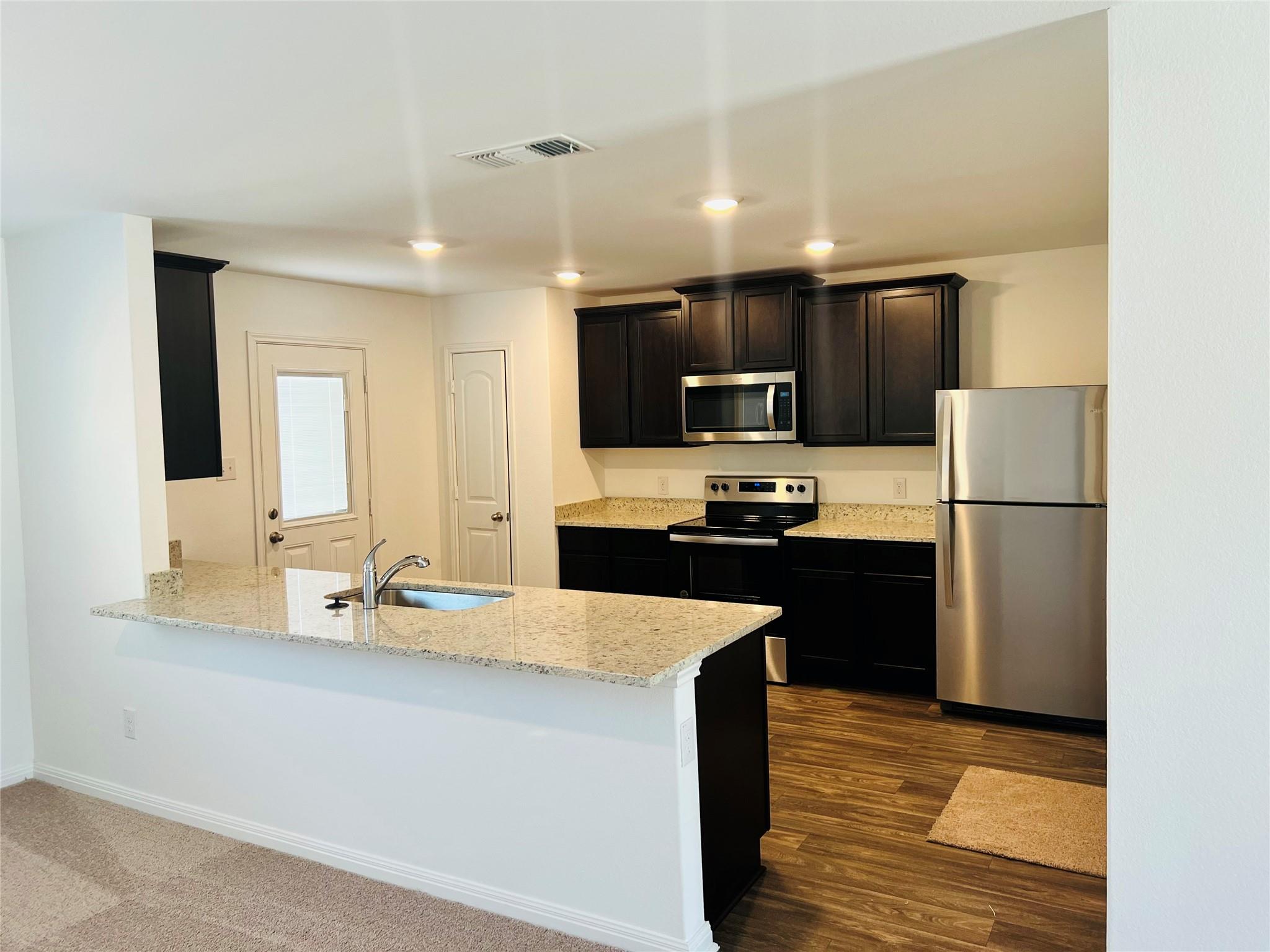 Rich dark cabinetry contrasts beautifully with gr