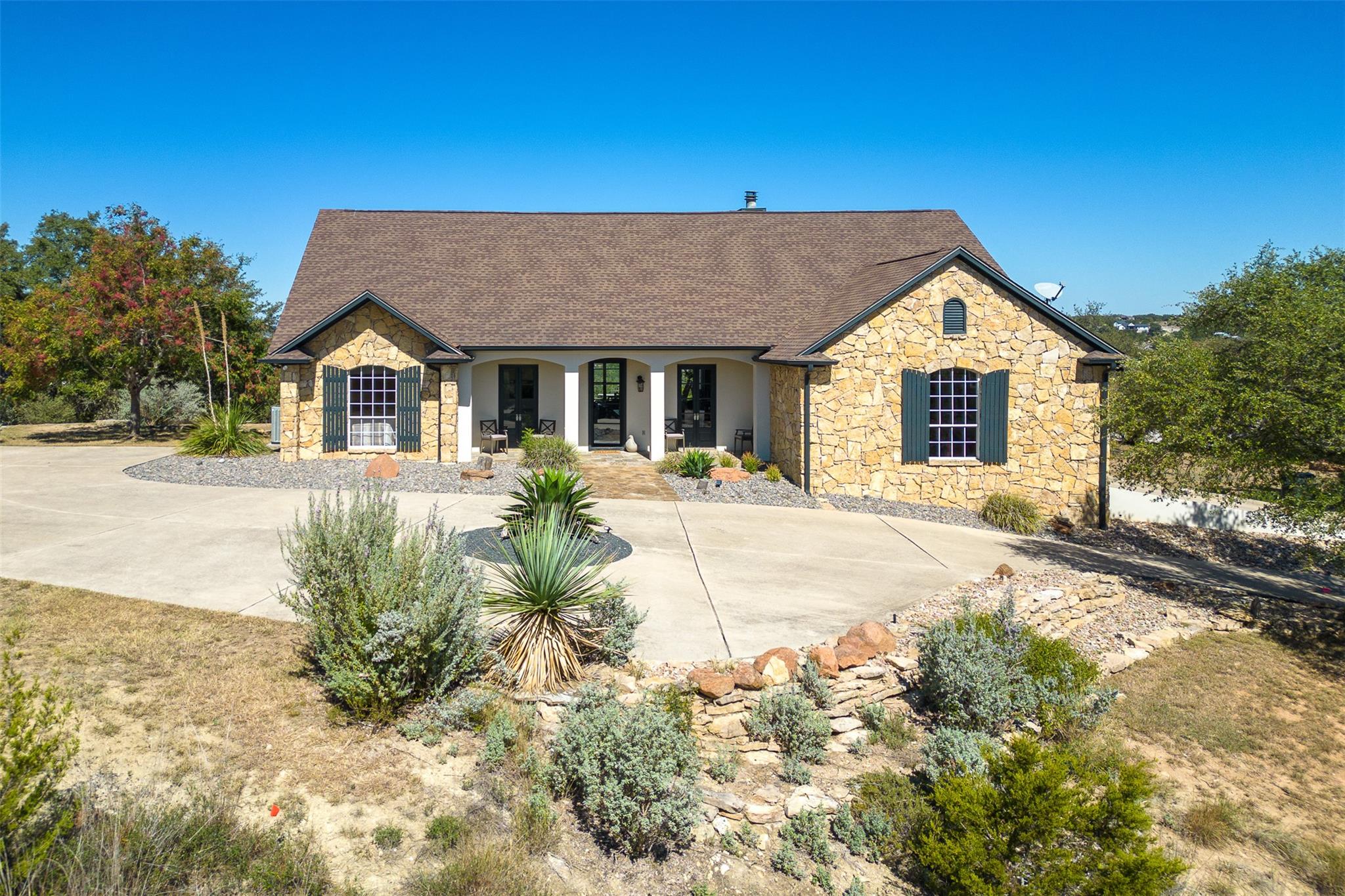Textured stone siding and a classic gabled roofli