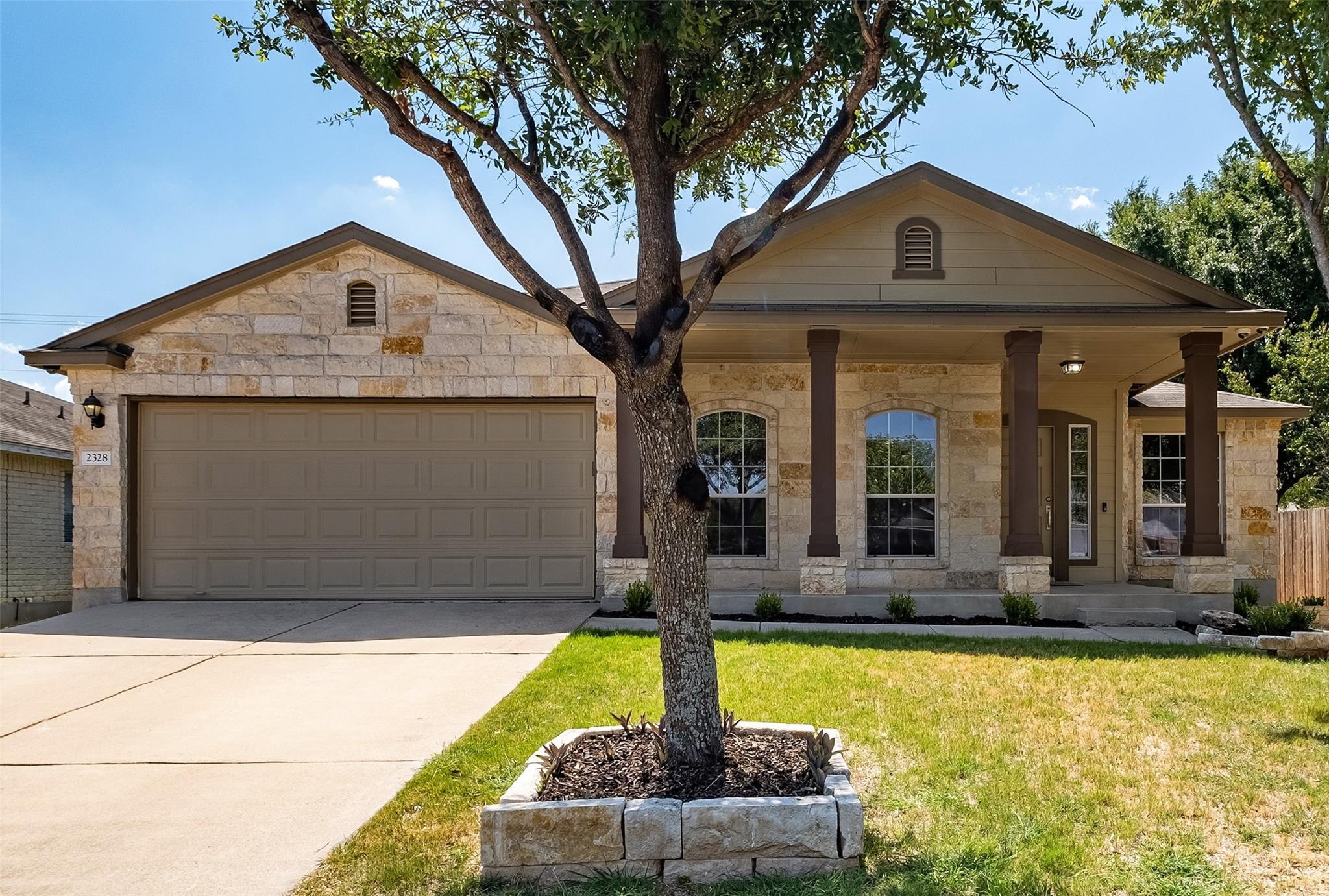 Textured stone veneer accents the exterior facade