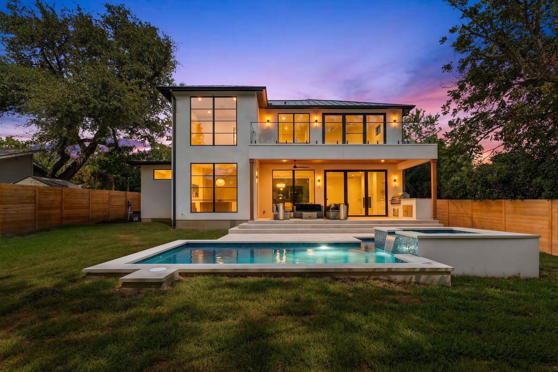 A contemporary stucco exterior opens to a grassy 