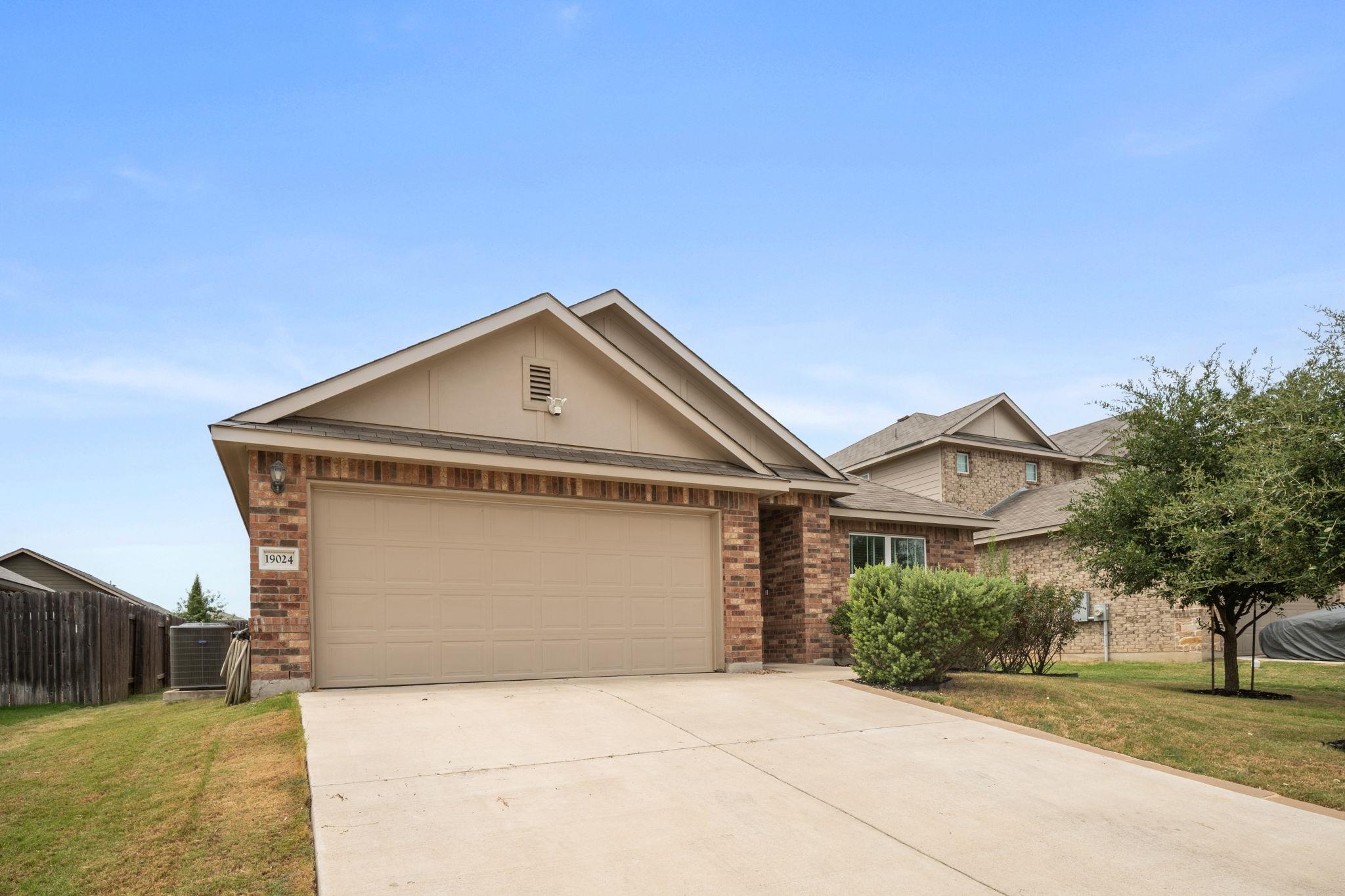 Classic brick accents and a spacious concrete dri